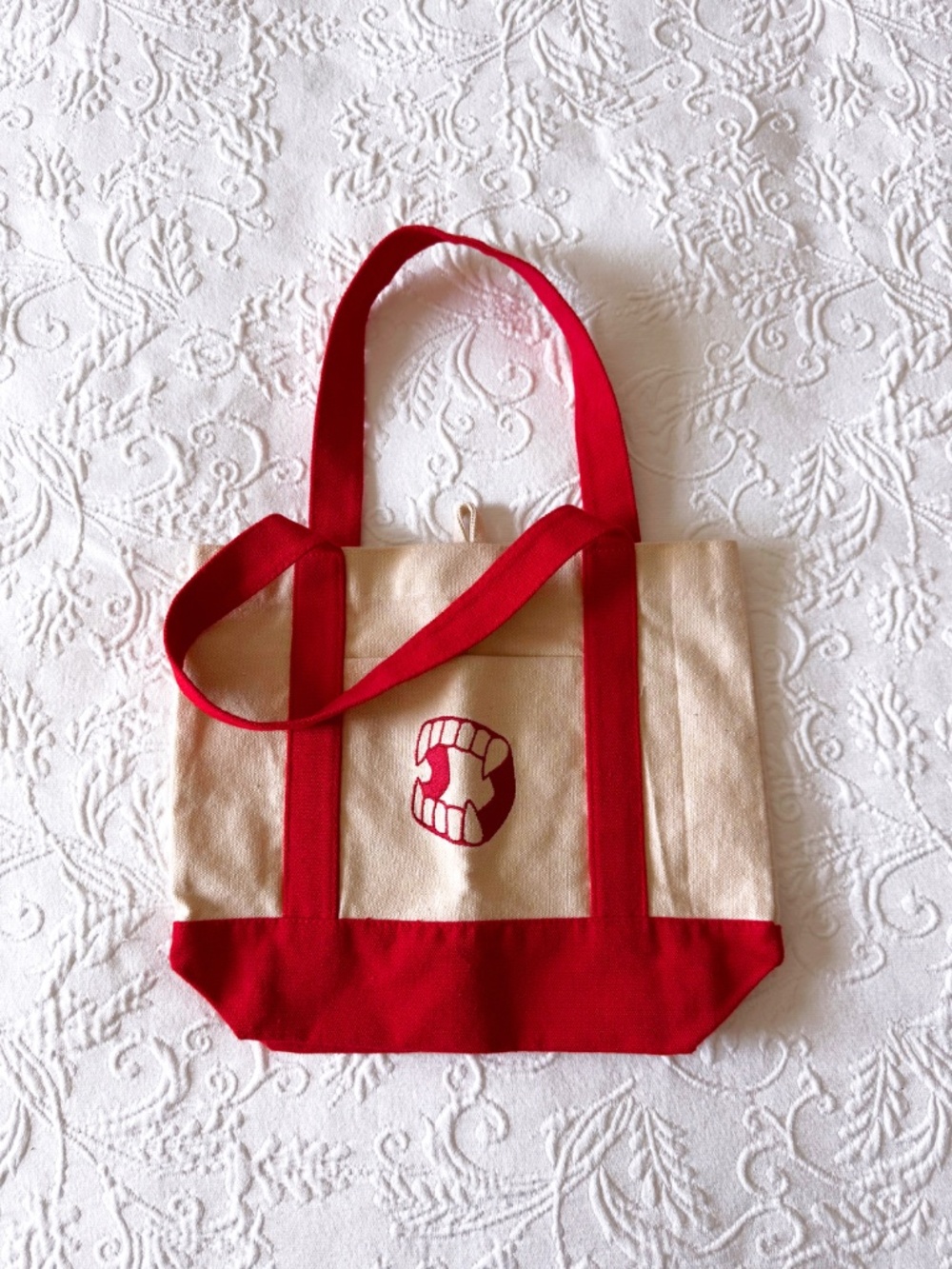spirit halloween mini canvas tote with embroidered vampire fangs in red
